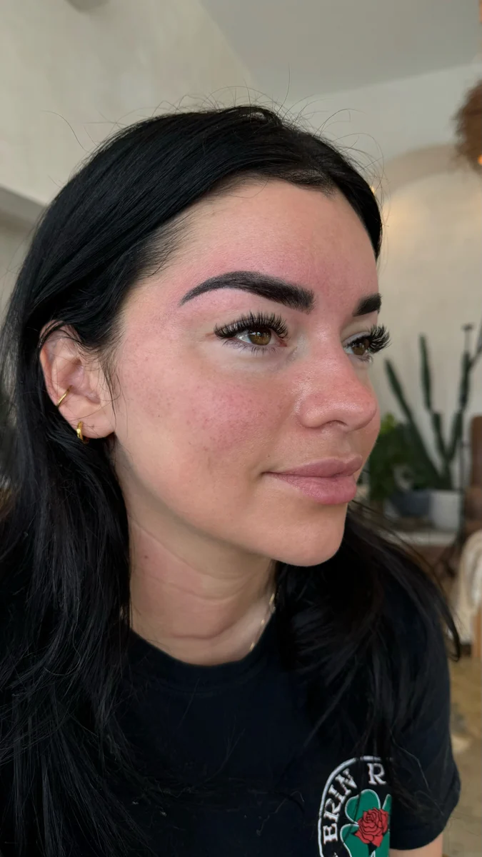 Client profile showing defined brows and curled lashes